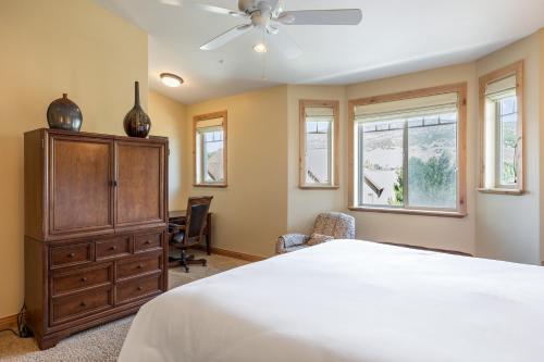 a bedroom with a bed and a dresser and windows at Spacious Retreat, Sleeps 7, Minutes to Skiing, Private Hot Tub, Scenic Views, Ultimate Relaxation! in Park City