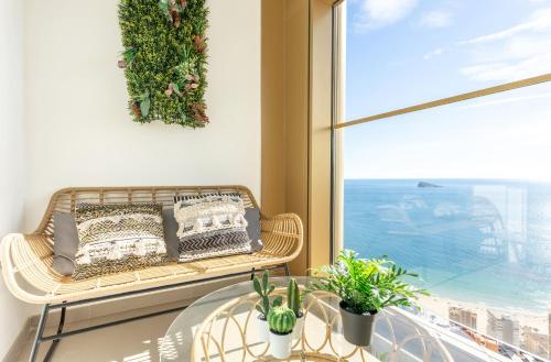 a balcony with a bench and a glass table and a window at Intempo by Holuxe - 292 -29th floor in Benidorm