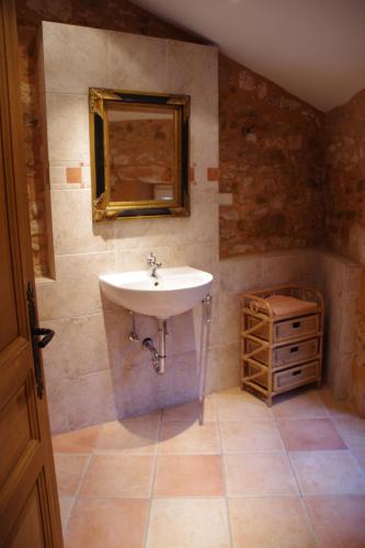 La salle de bains est pourvue d'un lavabo et d'une armoire en bois. dans l'établissement Petite Mombette, à Cénac-et-Saint-Julien