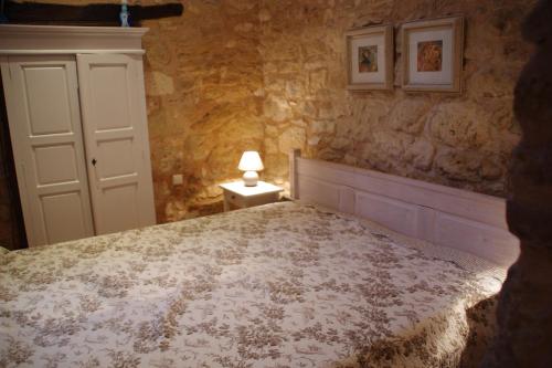 une chambre avec un lit et une lampe sur une table dans l'établissement Petite Mombette, à Cénac-et-Saint-Julien