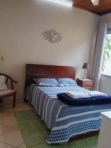 a bedroom with a bed with a blue blanket on it at Casa das Pedras in Lagoa Santa