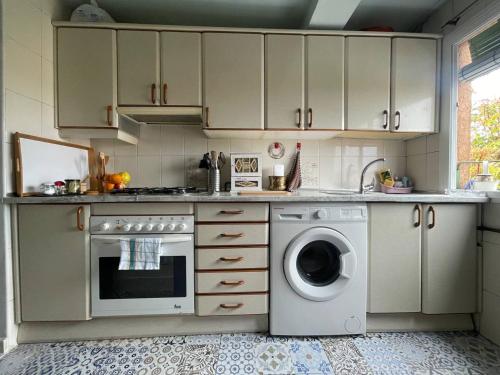 a kitchen with a stove and a washing machine at Piso con Vistas y Mucho Encanto in Madrid