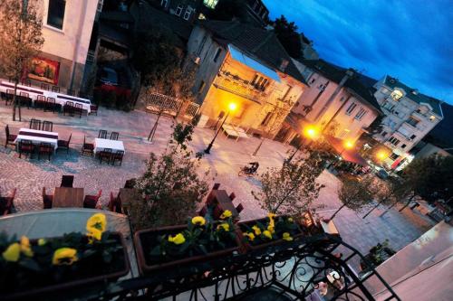 an overhead view of a courtyard with tables and yellow flowers at CENTRAL ROOMS WITH GREAT VIEW shared bathroom no parking in Skopje