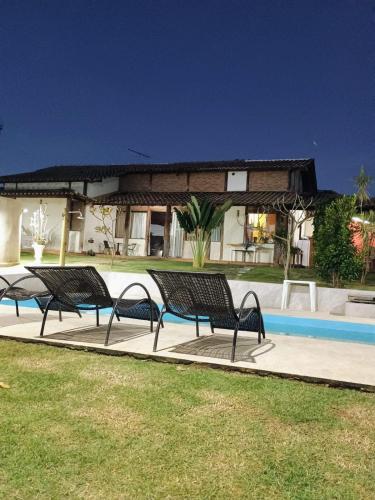 a group of benches sitting next to a swimming pool at Casa das Pedras in Lagoa Santa