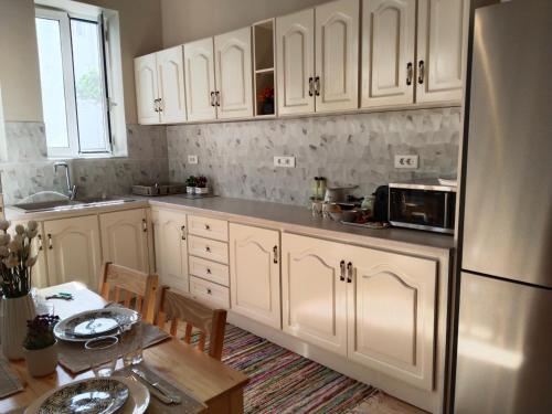 a kitchen with white cabinets and a wooden table with a tableablish at 1920 Classic in Kalamata