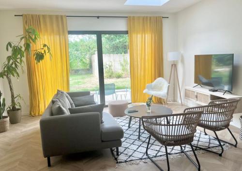 un salon avec un canapé et une table dans l'établissement Maison Joseph - Chambre 1, à Saint-Jacques-de-la-Lande