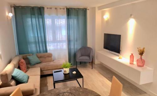 un soggiorno con un divano e una TV di Moderno apartamento con garaje privado en el centro de Vigo a Vigo