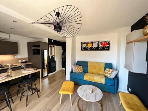un salon avec un canapé bleu et une cuisine dans l'établissement Appartement Cannes cosy vue mer, à Cannes