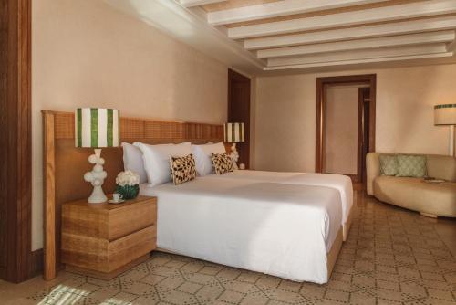 a bedroom with a large white bed and a couch at Royal Mansour Tamuda Bay in M'diq