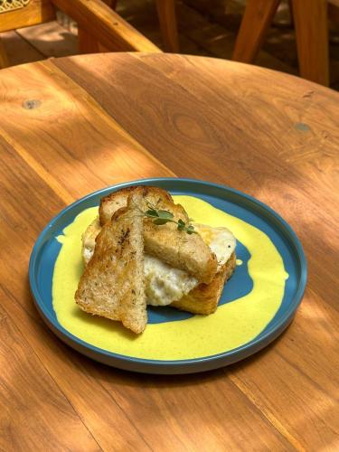 a blue and yellow plate with a sandwich on a table at Sky Breeze in Unawatuna