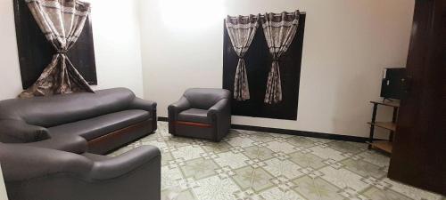 a living room with a couch and a chair at AHRA Green Garden in Mahabalipuram