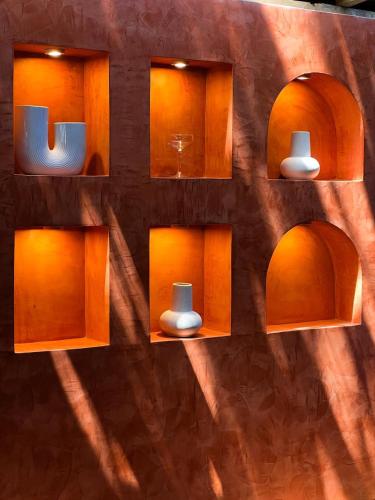 a wall with shelves with vases on it at Sky Breeze in Unawatuna