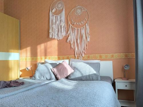 a bedroom with a bed with blue and pink pillows at Flip-Flops Apartment Jurmala with free parking in Jūrmala