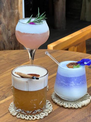 two cocktails on a wooden table with a drink at Sky Breeze in Unawatuna