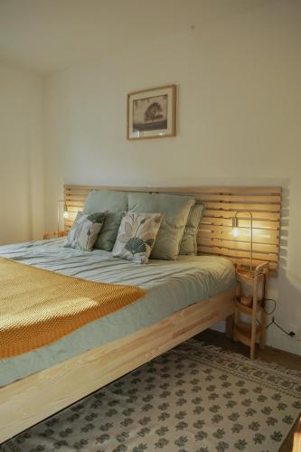 une chambre avec un grand lit avec une tête de lit en bois dans l'établissement Le Montarrouye Appartement pour 2 à 6 personnes, à Bagnères-de-Bigorre