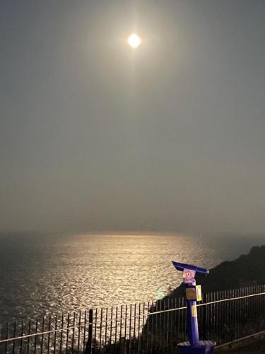 a view of the ocean with the moon in the sky at Headland View Boutique B&B in Torquay
