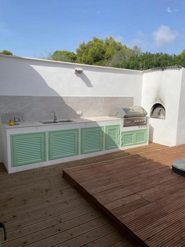 a kitchen with green cabinets and a sink on a deck at Beach House Mallorca in Cala Pi