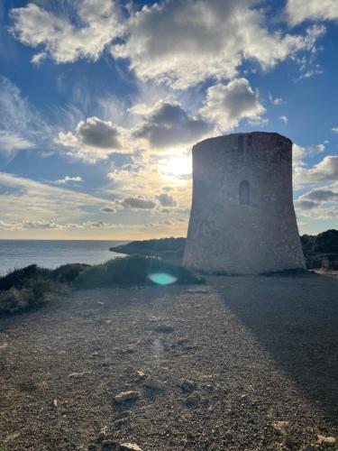 a tower on the shore of a body of water at Beach House Mallorca in Cala Pi