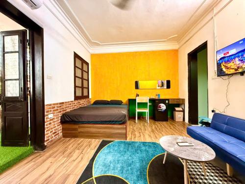 a bedroom with a bed and a blue couch at House with balcony,K Home 1,Old Quarter,3 mins to Hoankiem Lake in Hanoi