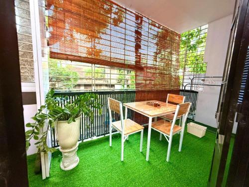 a table and chairs on a balcony with green grass at House with balcony,K Home 1,Old Quarter,3 mins to Hoankiem Lake in Hanoi