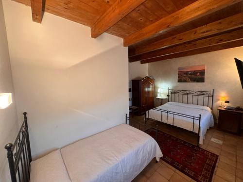 a bedroom with two beds and a wooden ceiling at Agriturismo Podere La Piazza in Costigliole dʼAsti