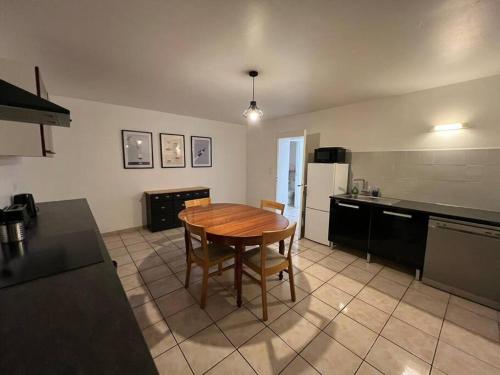 une cuisine avec une table en bois au milieu dans l'établissement Appartement spacieux 2 chambres 100m2 centre petite ville, à Longeville-lès-Saint-Avold