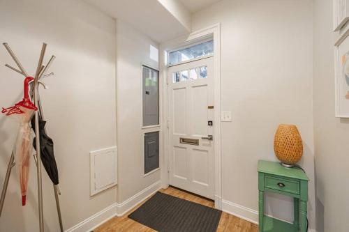 a hallway with a white door and a green table at Central LUX Apartment in DC in Washington, D.C.