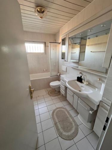 a bathroom with a sink and a toilet and a mirror at Villa Altdorf in Ettenheim