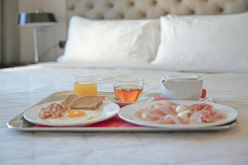 a tray with two plates of breakfast food on a bed at Hotel Europa in Reggio Emilia
