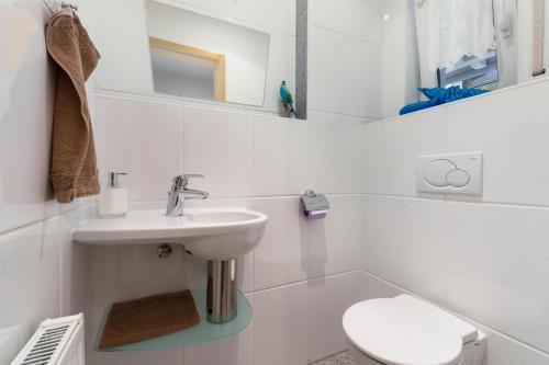 a white bathroom with a sink and a toilet at Haus Röcken in Dalaas