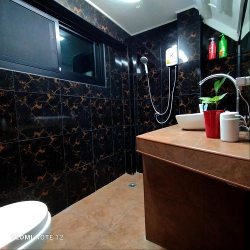 a bathroom with a shower and a sink and a toilet at CHILLI's Homes2 in Chiang Mai