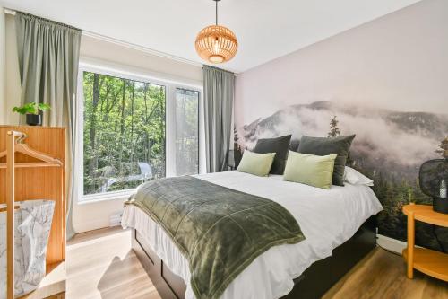a bedroom with a bed and a large window at Le Soren in Sainte Béatrix