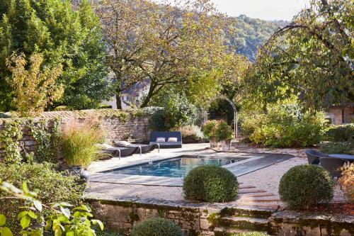 une piscine dans un jardin avec des chaises et des arbres dans l'établissement Le Clos des Rosiers, à Arbois