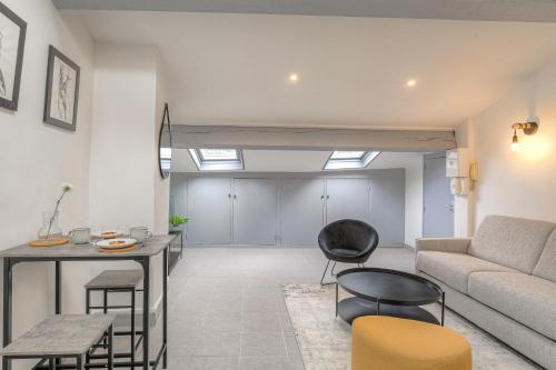 un salon avec un canapé, une table et des chaises dans l'établissement Le Cléret, Studio douillet sous les toits, à Vienne