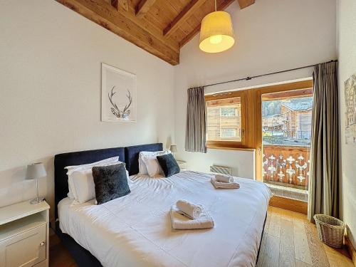 une chambre avec un grand lit avec deux serviettes dessus dans l'établissement Passa Franc - appartement- 8pers - proche piste, aux Gets