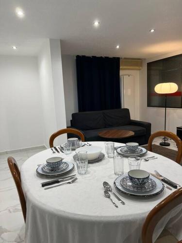 une table avec un chiffon de table blanc, des assiettes et de l'argenterie dans l'établissement Charmant appartement Strasbourg, à Strasbourg