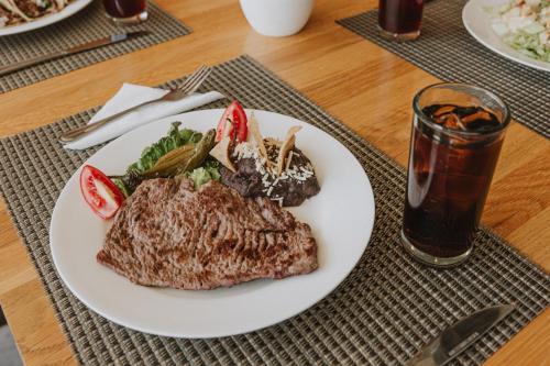 a plate of food with meat and vegetables and a drink at Hotel México Plaza Querétaro in Querétaro