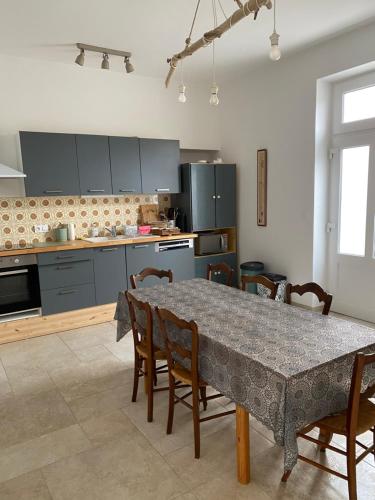 - une cuisine avec une table, des chaises et une table dans l'établissement ancienne ferme maison familiale, à Chaucre
