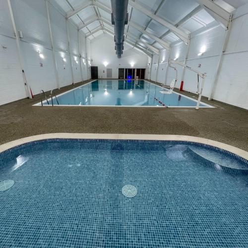 a large swimming pool with blue tiles in a building at Sunrise Cove, The Bay, Filey in Filey