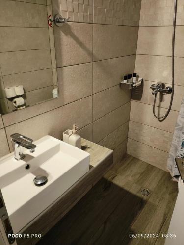 a bathroom with a white sink and a shower at elenamou rooms in Ammouliani
