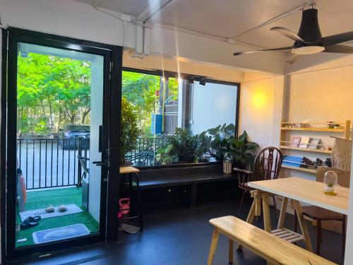 a room with a window and a table with chairs at Sleep like a baby Hostel Pattaya in Jomtien Beach