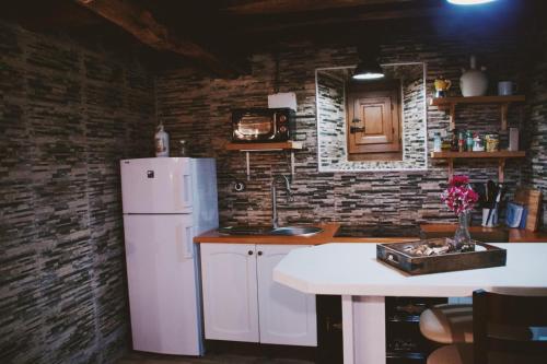 a kitchen with a white refrigerator and a table at Casa de Aldea in Aldea de San Esteban