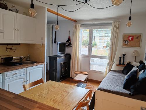 une cuisine et un salon avec une table et un canapé dans l'établissement Apt confortable au pied des pistes et de la forêt, à Bolquère-Pyrénées 2000