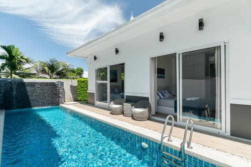 a villa with a swimming pool and a house at Friendly Kamala Garden View in Kamala Beach