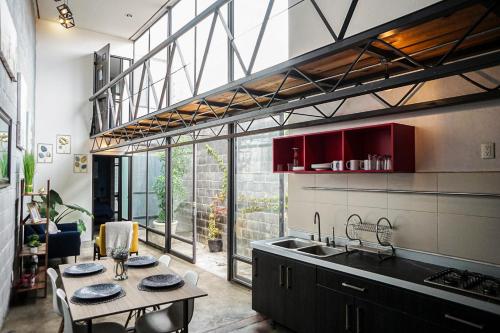 a kitchen with a table and a large window at Casa Cobre StayHouse in San Luis Potosí