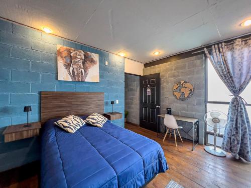 a bedroom with a blue bed and a blue wall at Casa Cobre StayHouse in San Luis Potosí
