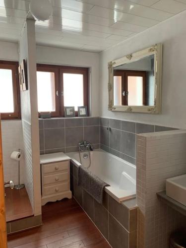 une salle de bain avec une baignoire, un lavabo et un miroir dans l'établissement Morzine apartment, perfect ski and summer base for 8, à Montriond
