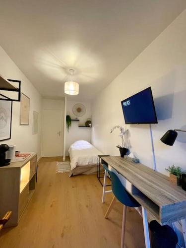 une pièce avec une chambre avec un lit et un bureau dans l'établissement Studio avec parking et terrasse, à Chartres