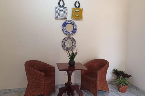 a table with two chairs and a mirror on a wall at Lumineux et cosy, entrée Bastos in Yaoundé