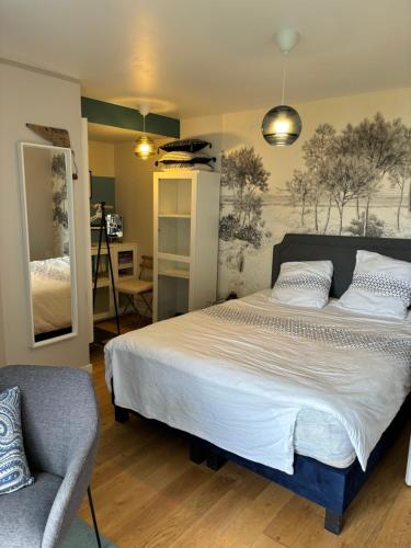 une chambre avec un grand lit et une chaise dans l'établissement Isis vue mer, à Douarnenez